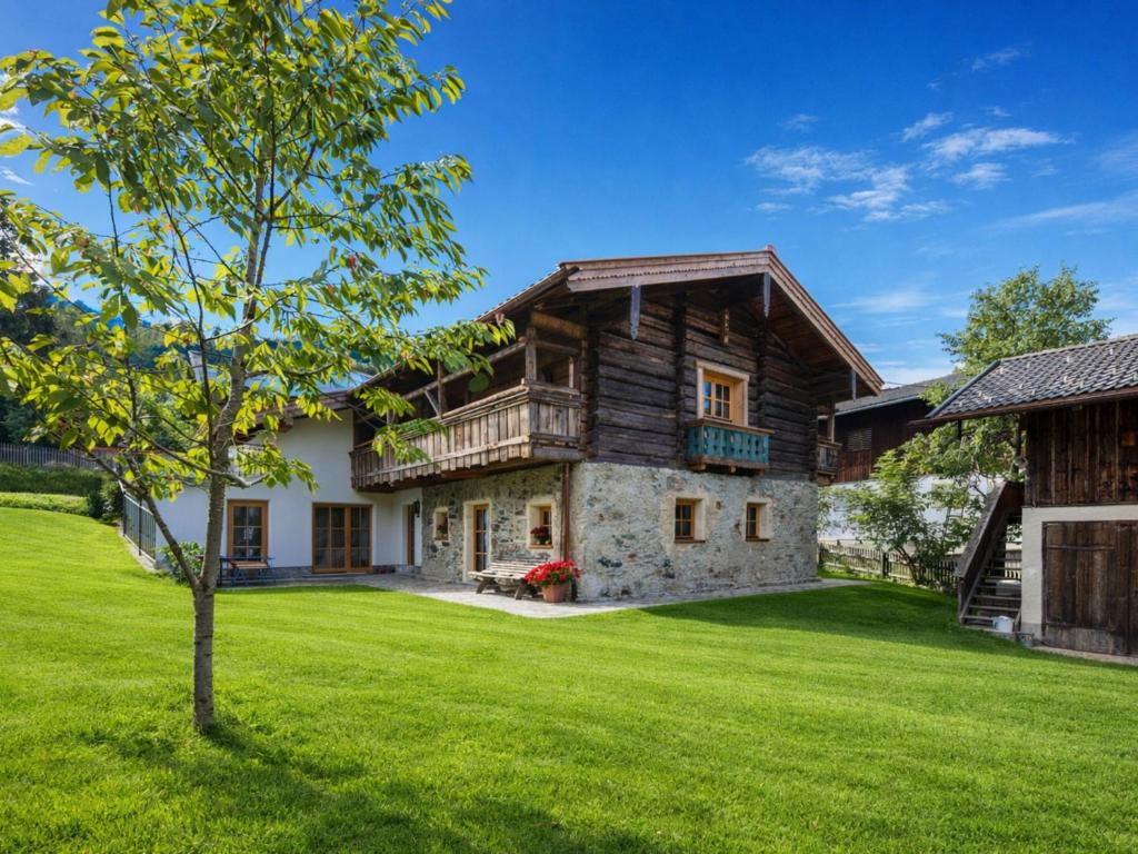 an exterior view of a log house with a yard at Kramerl in Bruck an der Großglocknerstraße