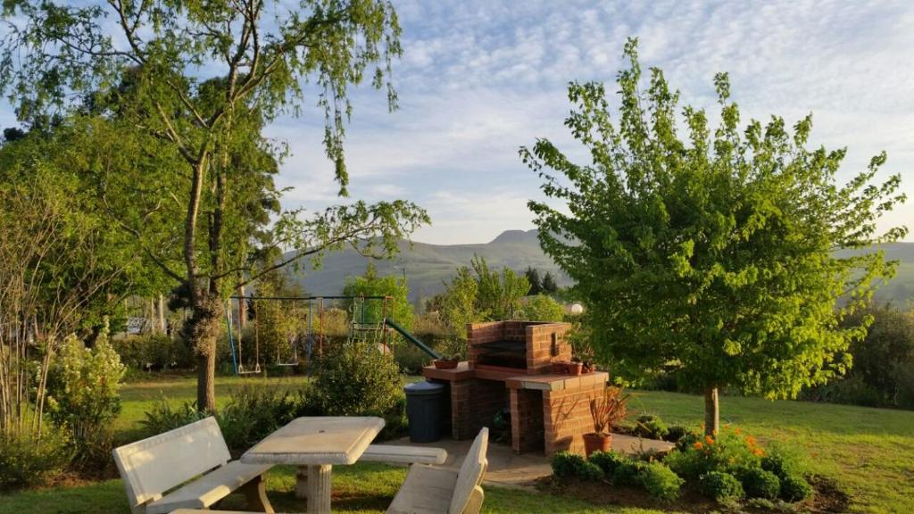 a picnic table and a grill in a yard at Sangwana 27 Holiday Home in Underberg