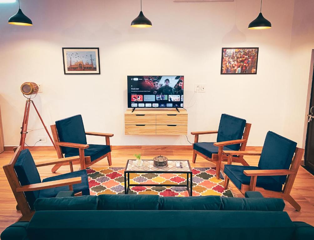 a living room with a couch and chairs and a tv at Comfort & Cozy, Villa in Orchha