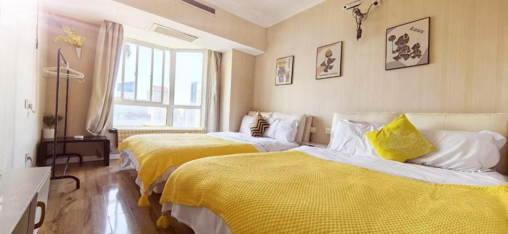 two beds in a room with yellow and white at Maizi Apartment Homestay, Shanghai in Shanghai