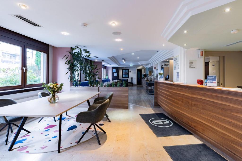 an office with a counter and a table and chairs at Garner Hotel Stuttgart City Centre by IHG in Stuttgart