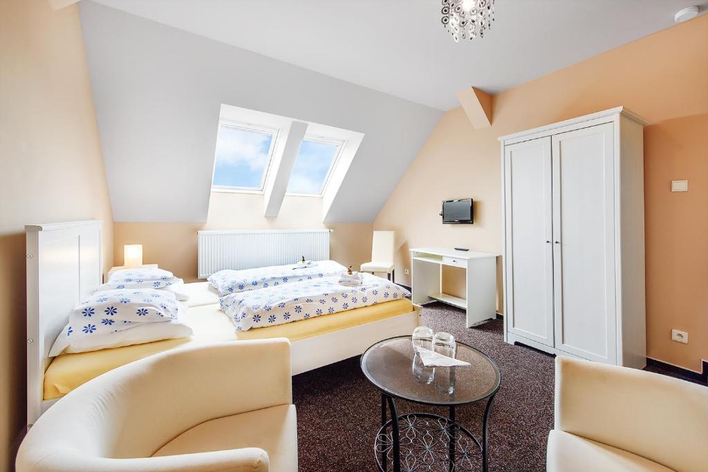 Bučovice的住宿－Penzion Sole，一间卧室配有两张床和一张桌子及椅子