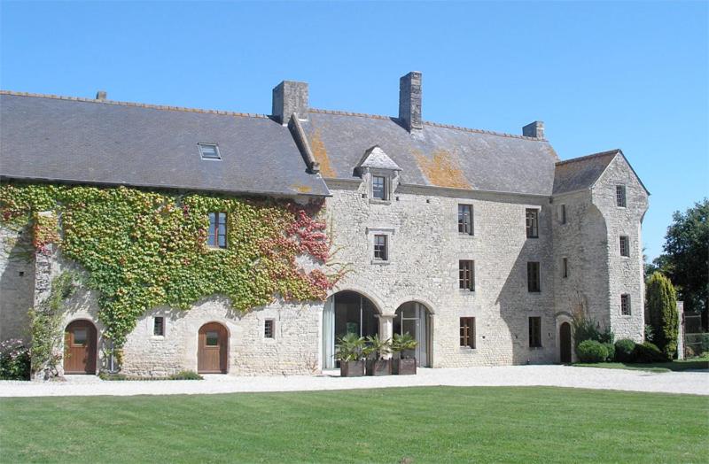 a large stone building with ivy growing on it at MANOIR du QUESNAY in Mandeville-en-Bessin