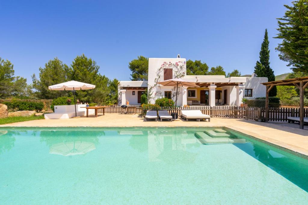 a swimming pool in front of a house at Sa Vinyeta in Sant Llorenç de Balafia
