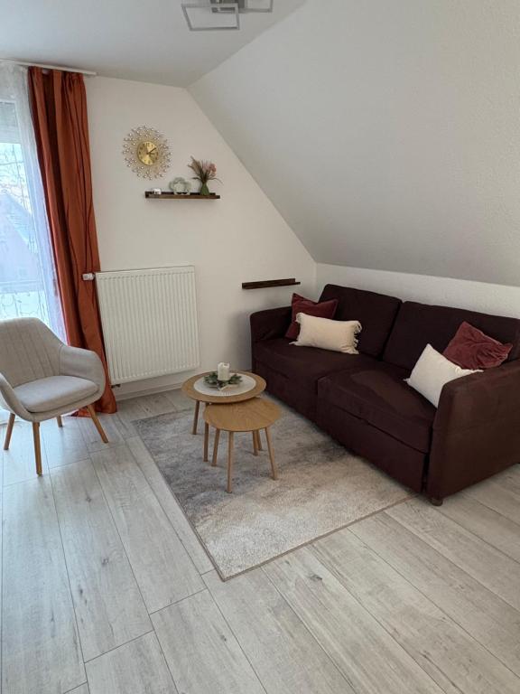a living room with a brown couch and a table at Apartement Seestern mit kleinem Südbalkon, 100m zum Meer in Steinhude