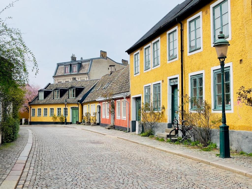 eine leere Straße in einer Altstadt mit gelben Häusern in der Unterkunft Studio 32 in Lund