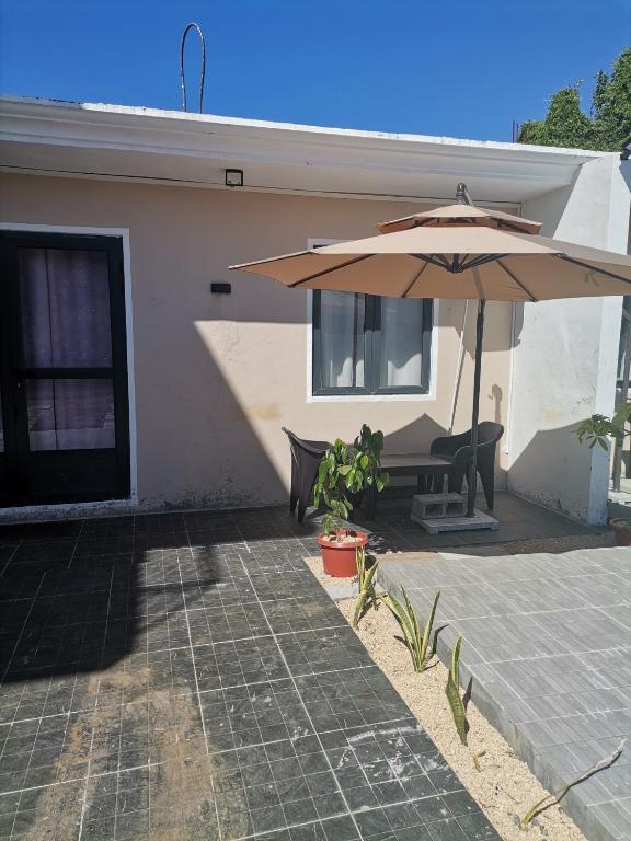 a house with a table and an umbrella at Serene Villa in Grand-Baie