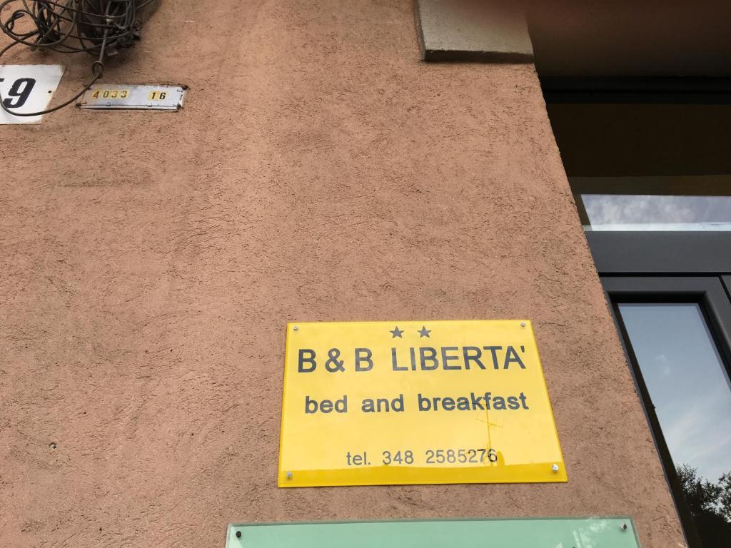 una señal amarilla en el lateral de un edificio en B&B Libertà, en Biella