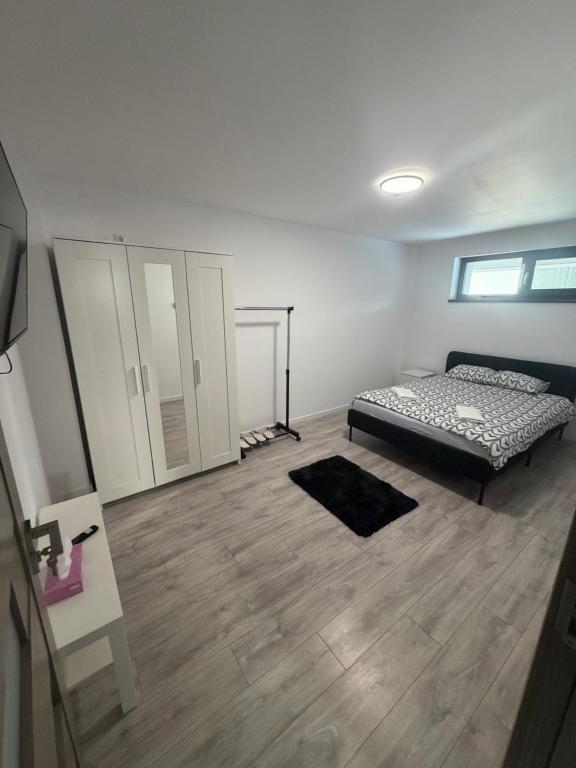 a bedroom with a bed and a wooden floor at EVEREST 33 Garsoniera in Bucharest