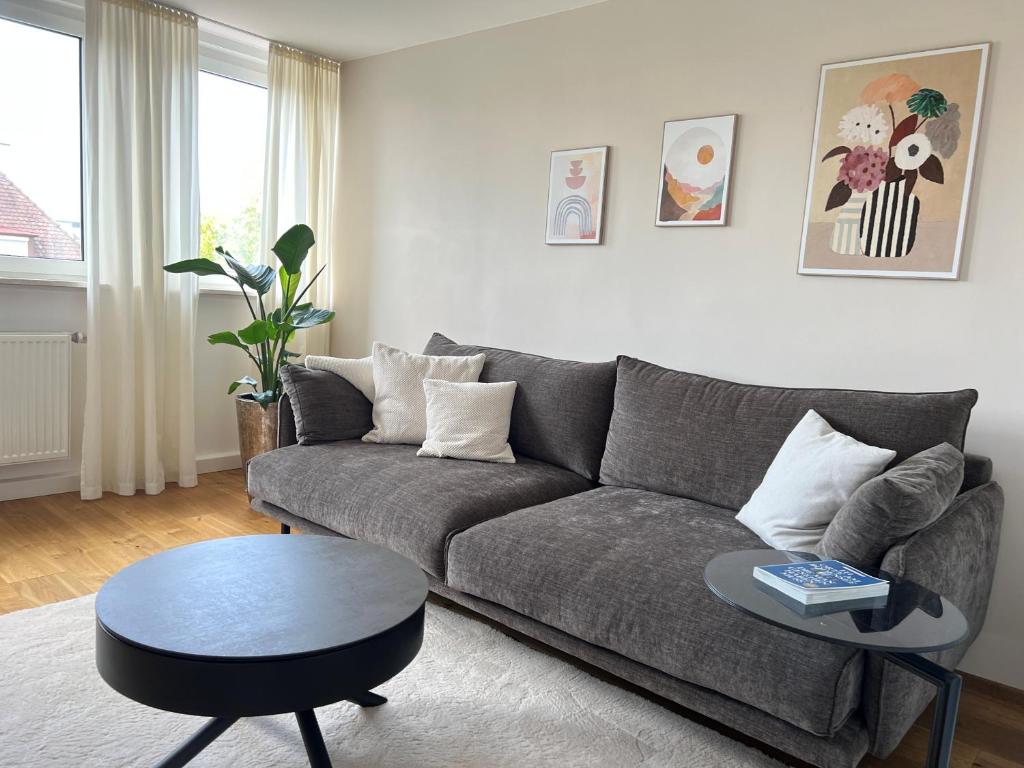 a living room with a gray couch and a table at Ferienwohnung Bodenseeparadies in Friedrichshafen