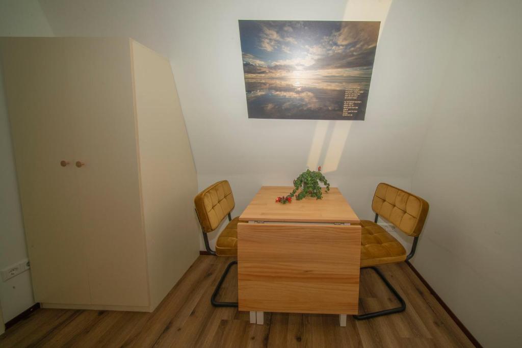 a table and chairs in a room with a picture on the wall at Studio De Gravin in Gouda