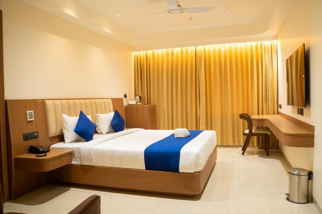 a hotel room with a bed and a desk and a bed sidx sidx at AAA URBAN STAY-Madhapur in Hyderabad