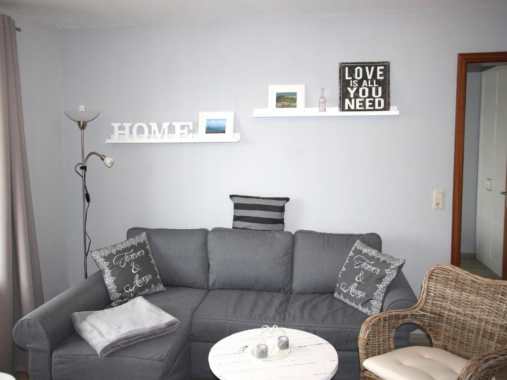 ein Wohnzimmer mit einem grauen Sofa und einem Tisch in der Unterkunft Lagunenstadt am Haff GmbH in Ueckermünde