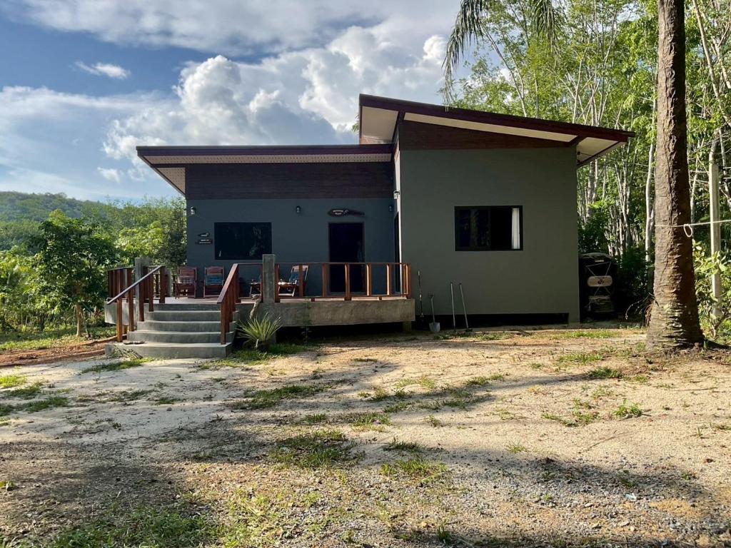 a small house with a porch and stairs to it at Baan Mada Lanta villa in Ko Lanta