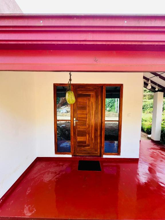 a house with a red floor and a wooden door at D Villa Nuwara Eliya in Sita Eliya
