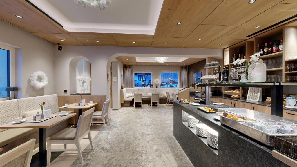 a restaurant with tables and chairs and a bar at Café-Pension Erika in Pertisau