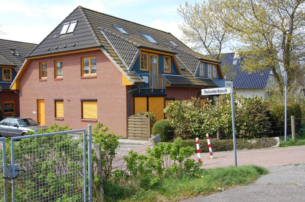 una casa con una recinzione di fronte di Apartment Holunderbusch a Schönberger Strand