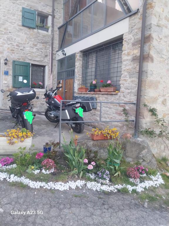 a motorcycle parked in front of a building with flowers at La corte dei celti 9 in Quinzano