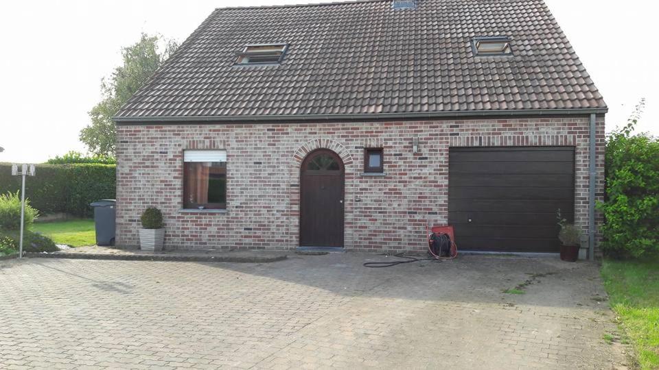 una casa de ladrillo con garaje y entrada en At the Villa en Tournai
