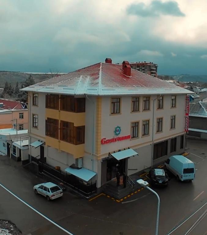 a building with cars parked in a parking lot at RAA apartments in Qusar