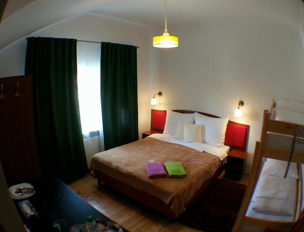 a bedroom with a large bed with green curtains at Moniuszki24 in Świnoujście