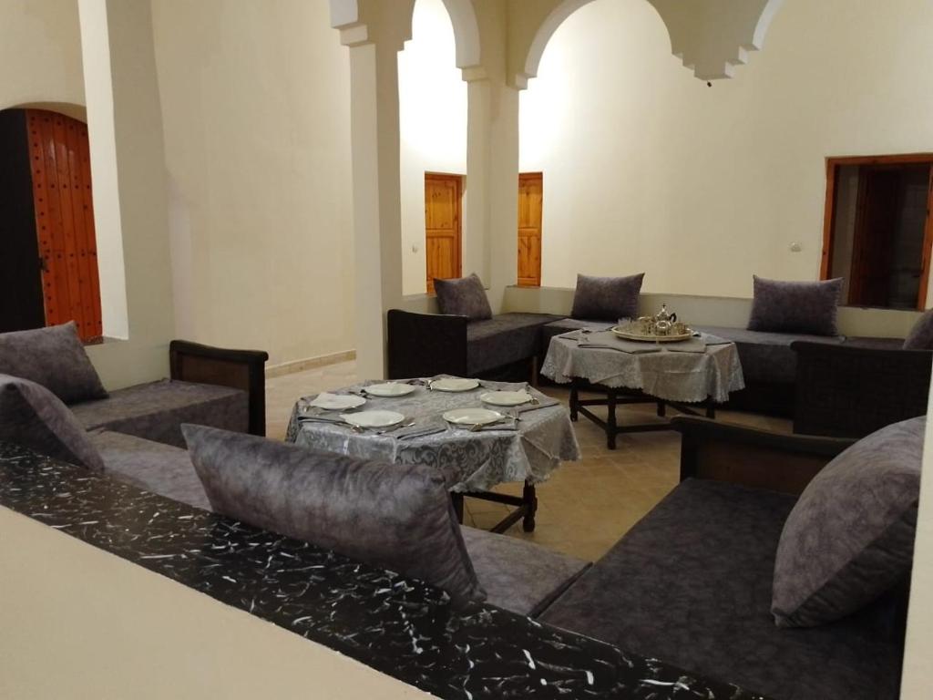 a living room with couches and a table and chairs at Kasbah Anisi in Irhels