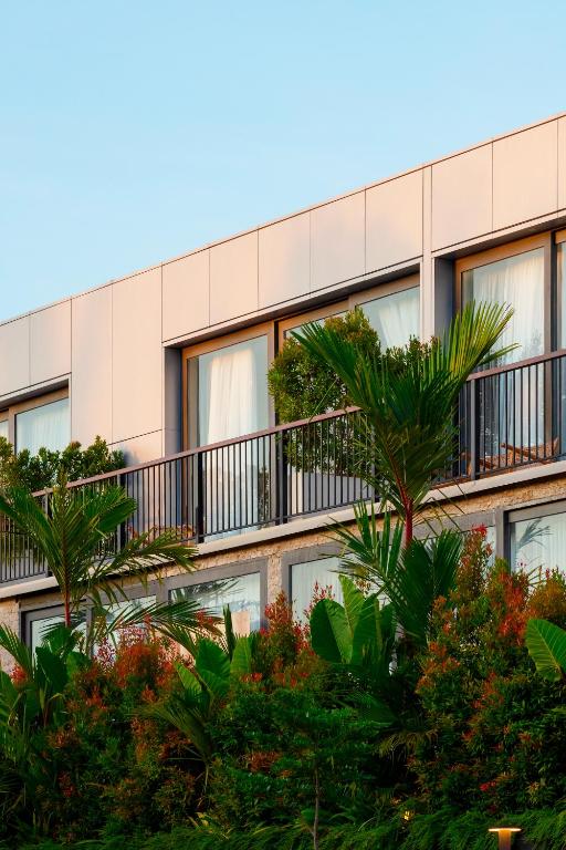 an apartment building with trees in front of it at Hidden City Ubud - Modern Comfort & Relaxed Living near Central Ubud and Green Fields in Ubud
