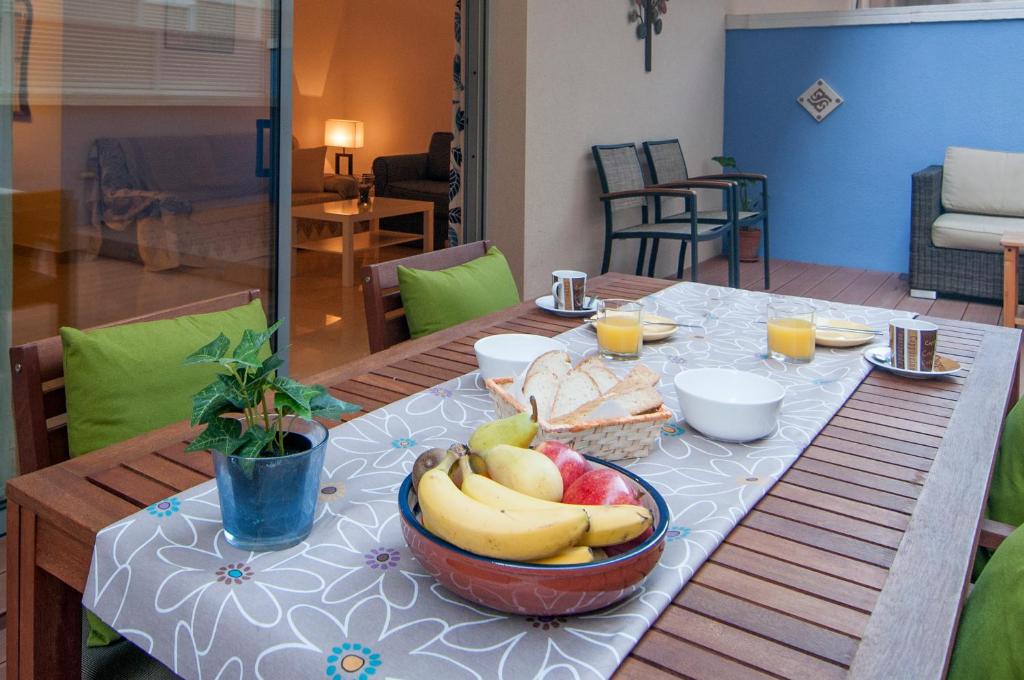 a table with a bowl of bananas and bread on it at Hola! - Sitges by the beach in Sitges