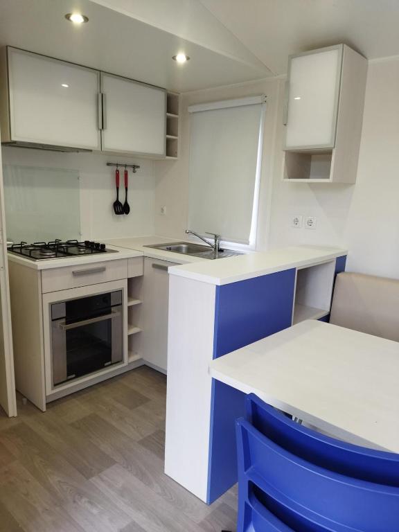 chalet 2 في Saint-Christol-lès-Alès: مطبخ بخزائن بيضاء وفرن موقد