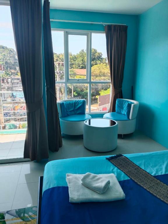 a room with a bed and two chairs and a window at Bedroom301 Kata Beach Phuket in Kata Beach