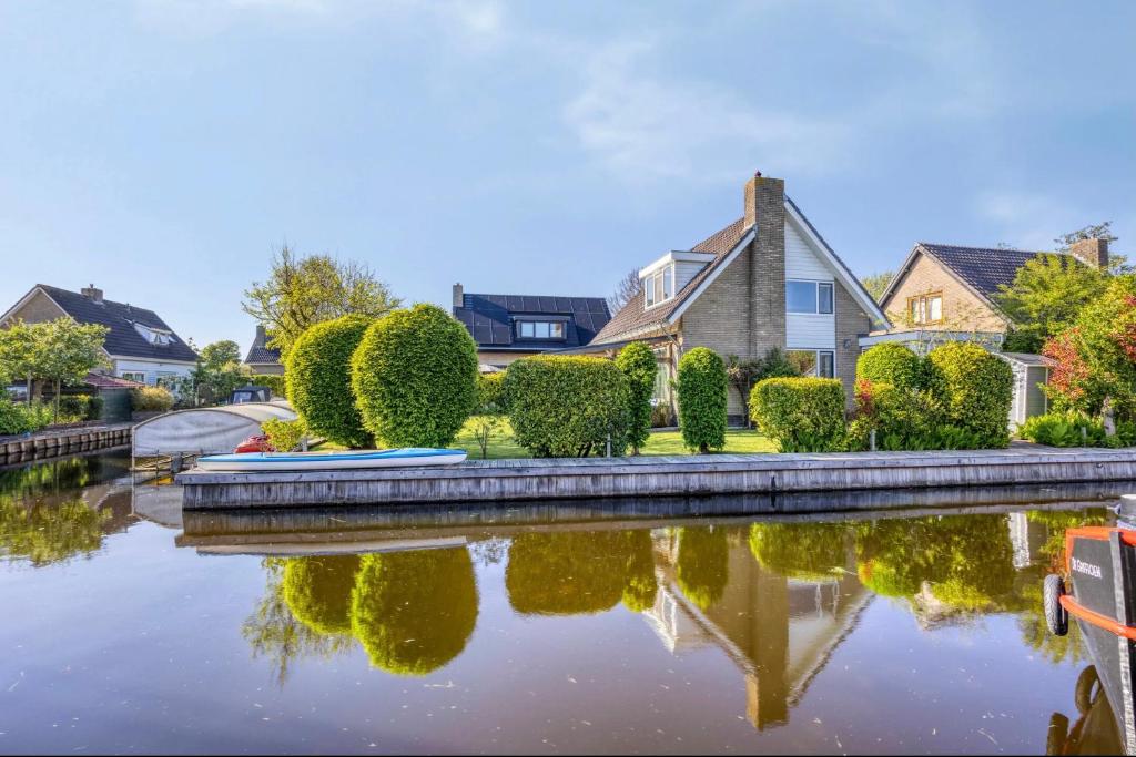 a house with a pond in front of a house at Zonnehoek Terherne in Terherne