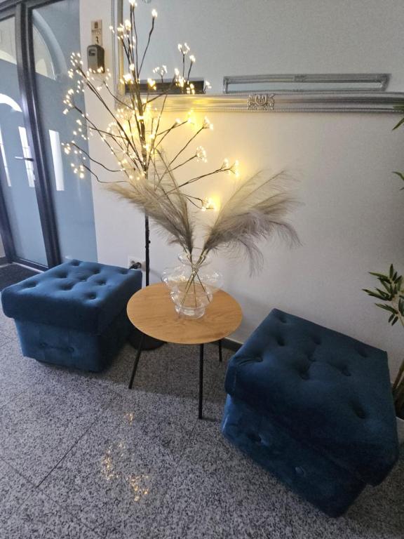 a living room with a table and two blue ottomans at Perfect Ploiesti in Ploieşti