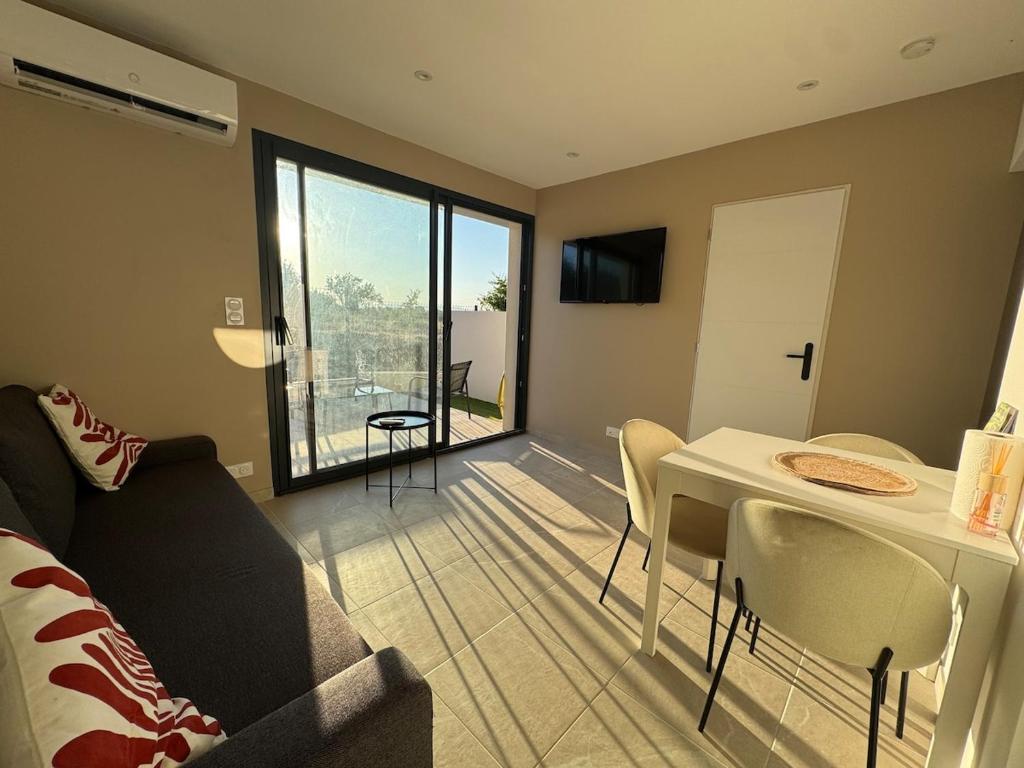 Una sala de estar con un sofá y una mesa con sillas. en La maisonnette, en Montblanc