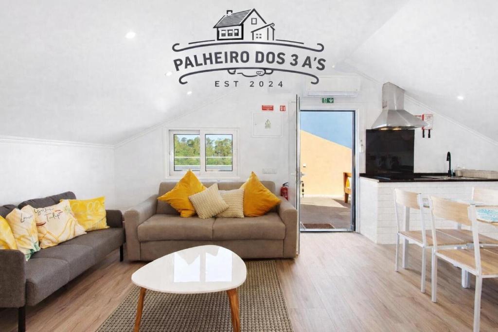 a living room with a couch and a table at Palheiro dos 3 A`s in Achadas da Cruz