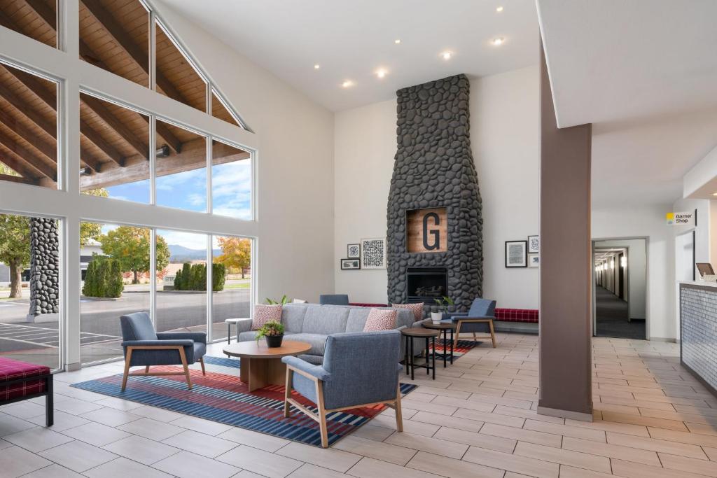 a lobby with a fireplace and chairs and a couch at Garner Hotel Liberty Lake by IHG in Liberty Lake
