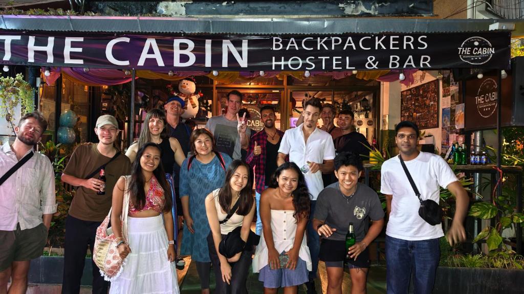a group of people standing in front of a bar at The Cabin Backpackers Hostel & Bar in Chiang Mai