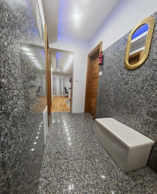 a bathroom with a toilet and a wall at Apartman Antonela in Sop