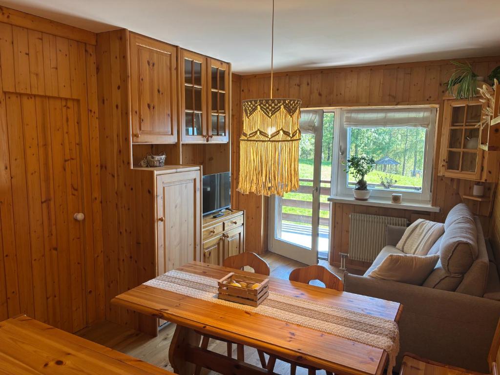 a living room with a table and a couch at Il Nido - Family Apartment con Spa & Mini Club a Cavalese in Carano