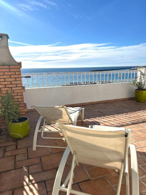 a patio with two chairs and a view of the ocean at Casa Eugenia in Sesimbra