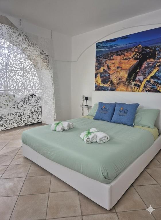 a bedroom with a large bed with towels on it at Sa domu pitticca Cavour in Cagliari