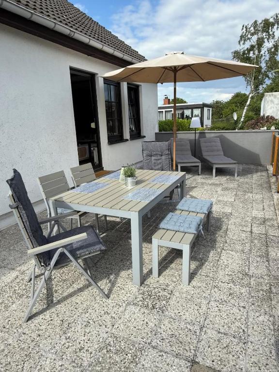a table and chairs and an umbrella on a patio at Strandgut- die Große in Dranske