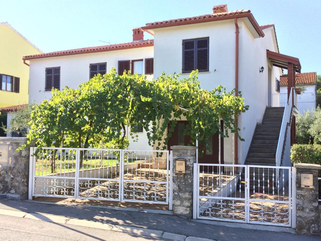 una casa blanca con una puerta y árboles en Apartments Carmelo, en Rovinj