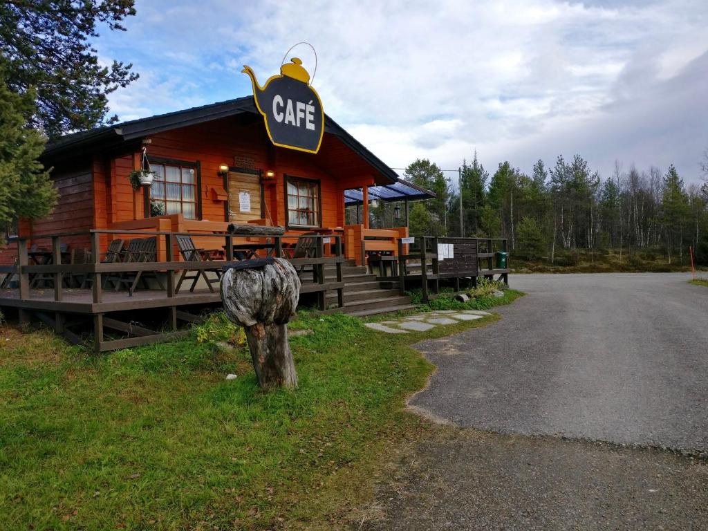 a log cabin with a cafe sign on it at Peurasuvanto Mökit & Camping in Peurasuvanto