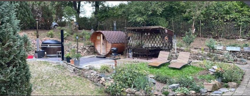a backyard with a grill and benches in a yard at Ferienhaus Vogtland mit Sauna und Hot Tub in Weischlitz