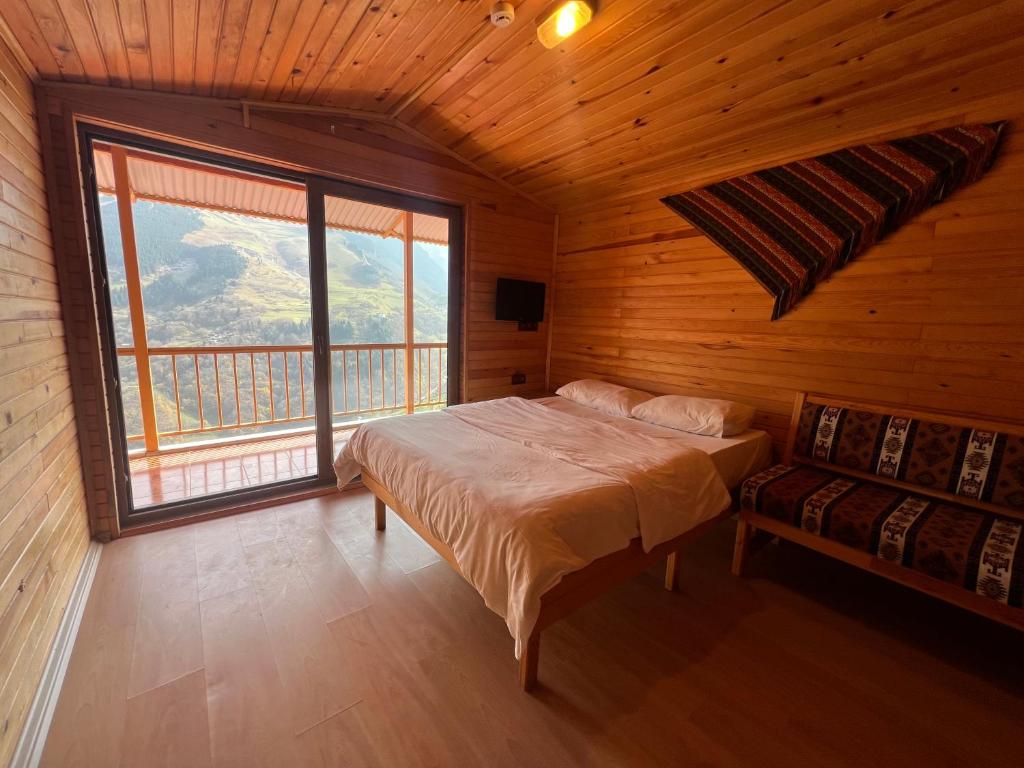 a bedroom with a bed and a large window at Hamsiköy Seyirtepe Butik Otel in Hamsikoy