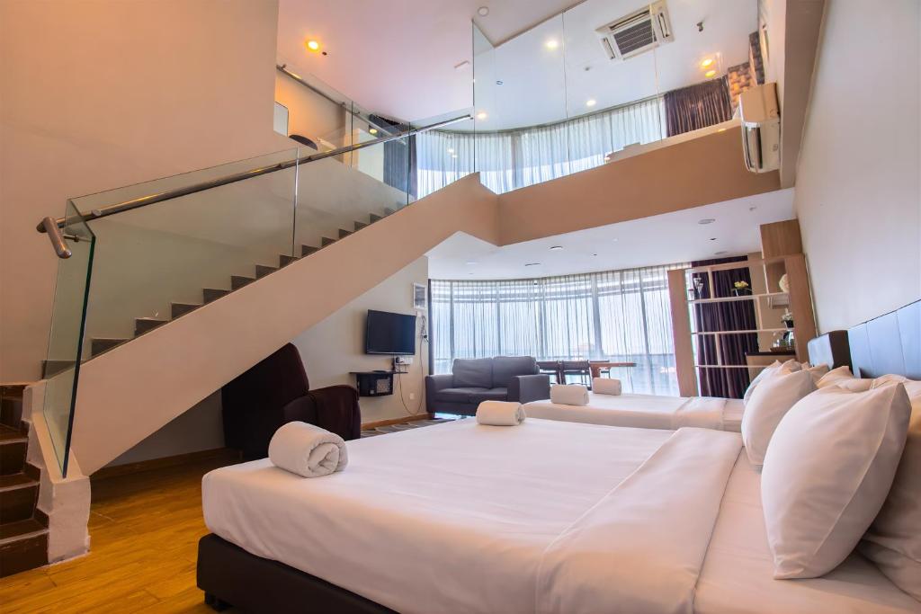a bedroom with a large bed and a staircase at Bangi Perdana Hotel in Bangi