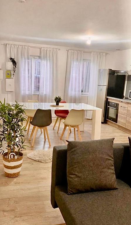 een woonkamer met een bank, een tafel en stoelen bij Duplex 