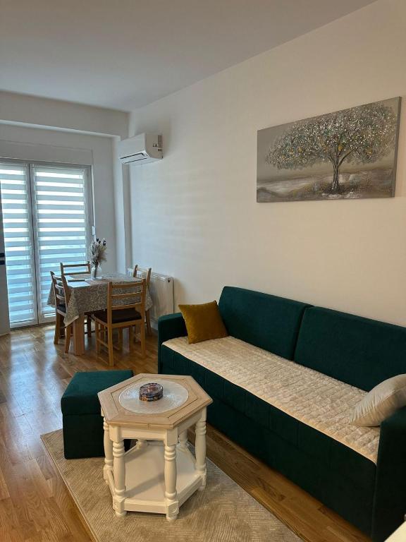 a living room with a green couch and a table at Apartman Lady A2 Istočno Sarajevo in Vranješ