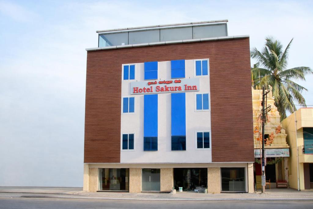 a building with a sign on the side of it at Hotel Sakura Inn in Hosūr