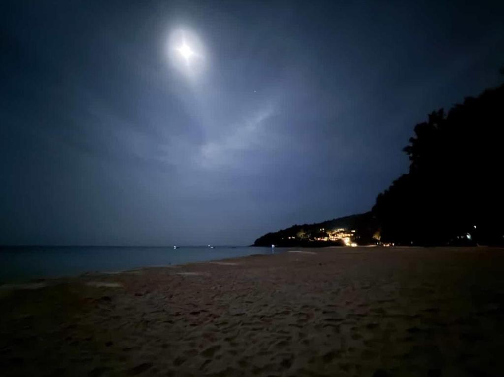 a moonrise over a sandy beach at night at EnDanni Home in Ban Phak Chit